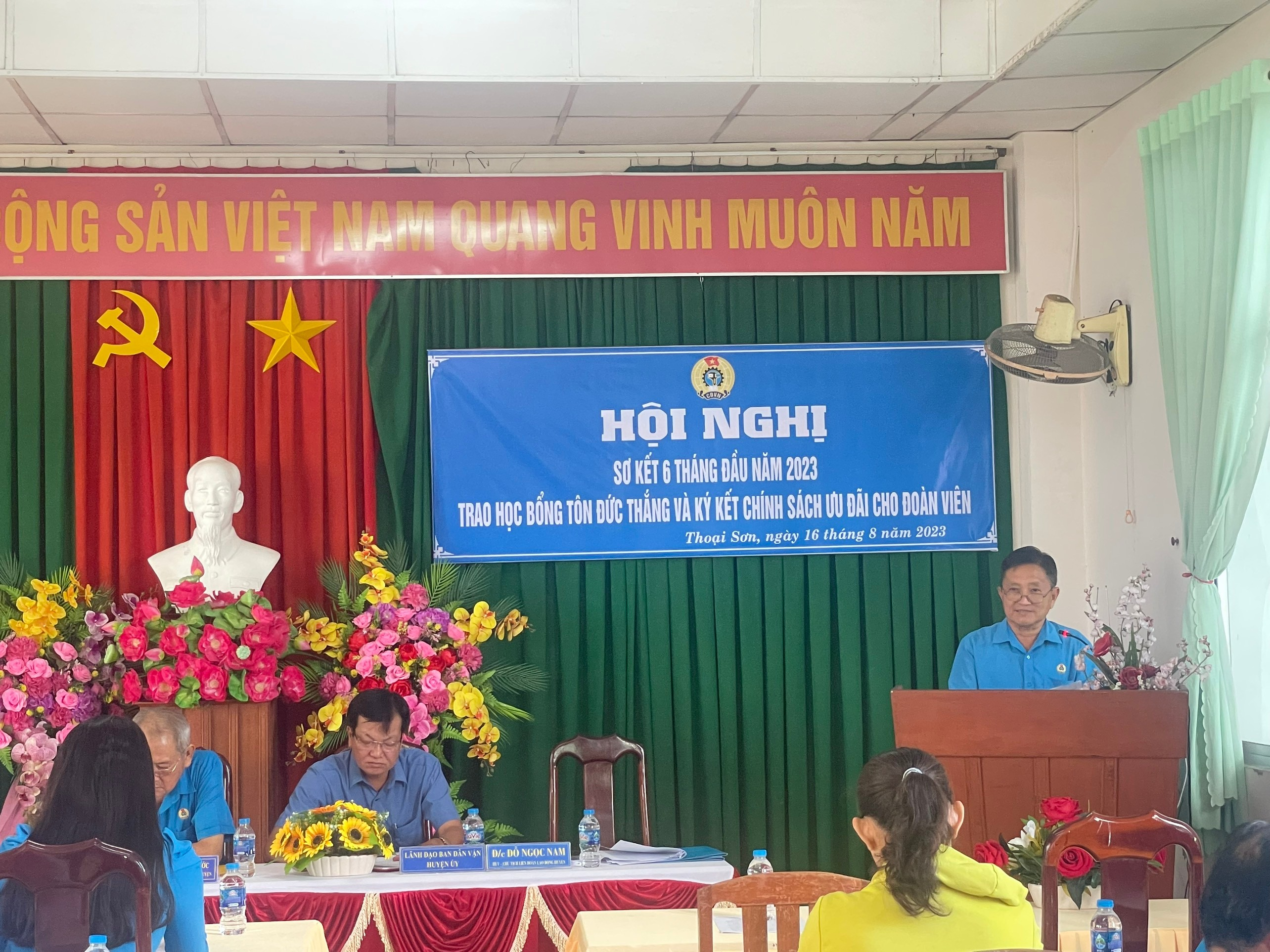 A group of people sitting at a podium Description automatically generated