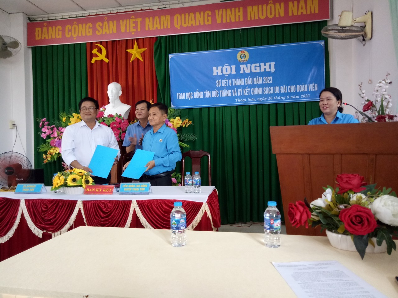 A group of people standing at a podium Description automatically generated