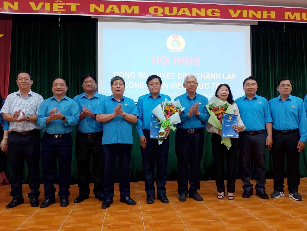 Phó Chủ tịch Thường trực Công đoàn Viên chức Việt Nam Nguyễn Văn Đông và Chủ tịch LĐLĐ tỉnh An Giang Nguyễn Thiện Phú trao Quyết định và tặng hoa chúc mừng. Ảnh: Lâm Điền 