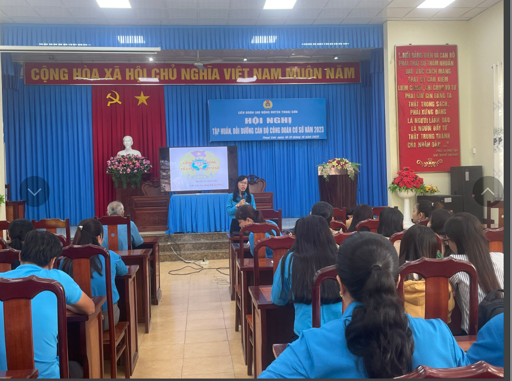 A person in blue shirt giving a presentation to a group of people Description automatically generated