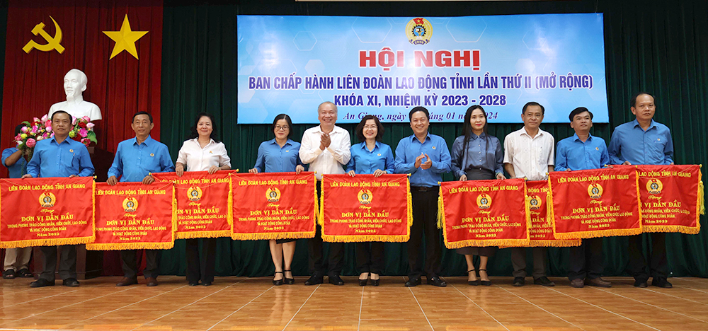 A group of people holding banners Description automatically generated