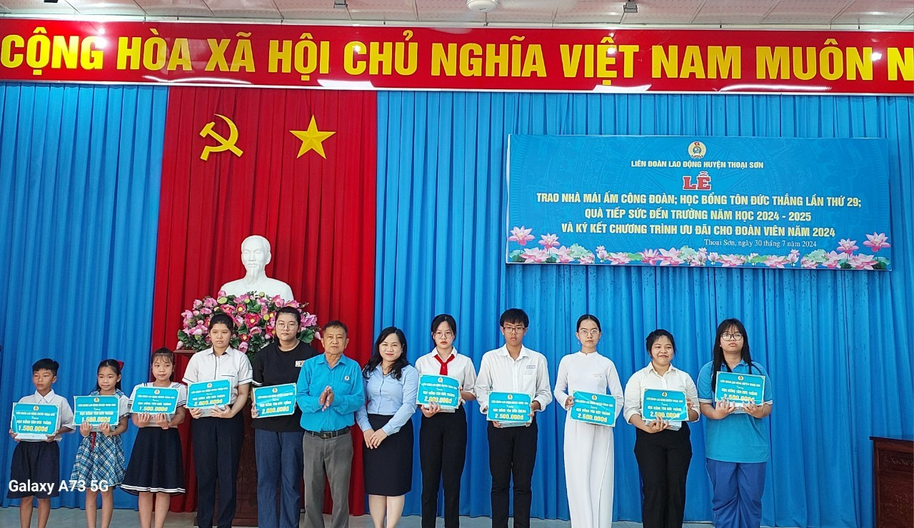 A group of people standing in front of a blue curtain

Description automatically generated