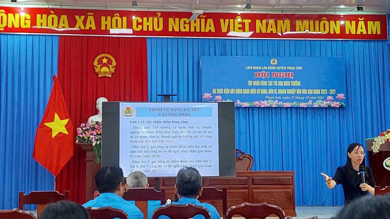 A group of people in front of a screen Description automatically generated